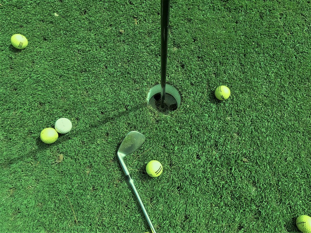 Six Golf Balls Near Hole. From Unsplash